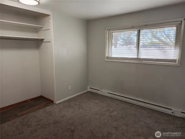 an empty room with closet and mirror