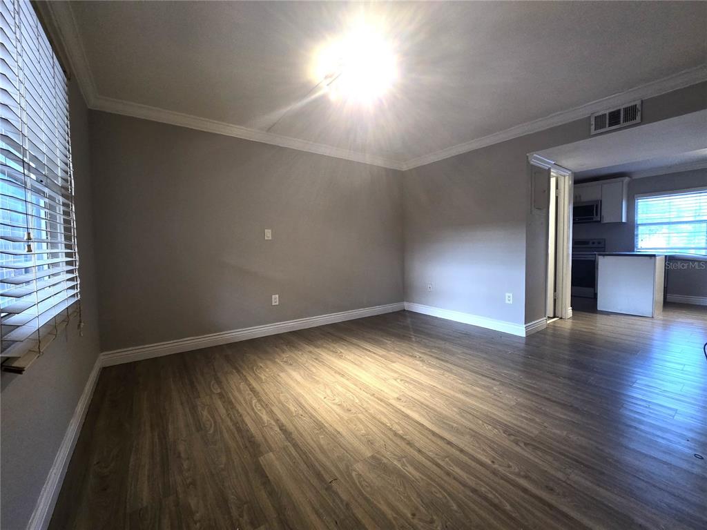 914 Southwest 8th Avenue, Unit 57 Gainesville, FL 32601 - Photo 15 of 31 an empty room with wooden floor and windows