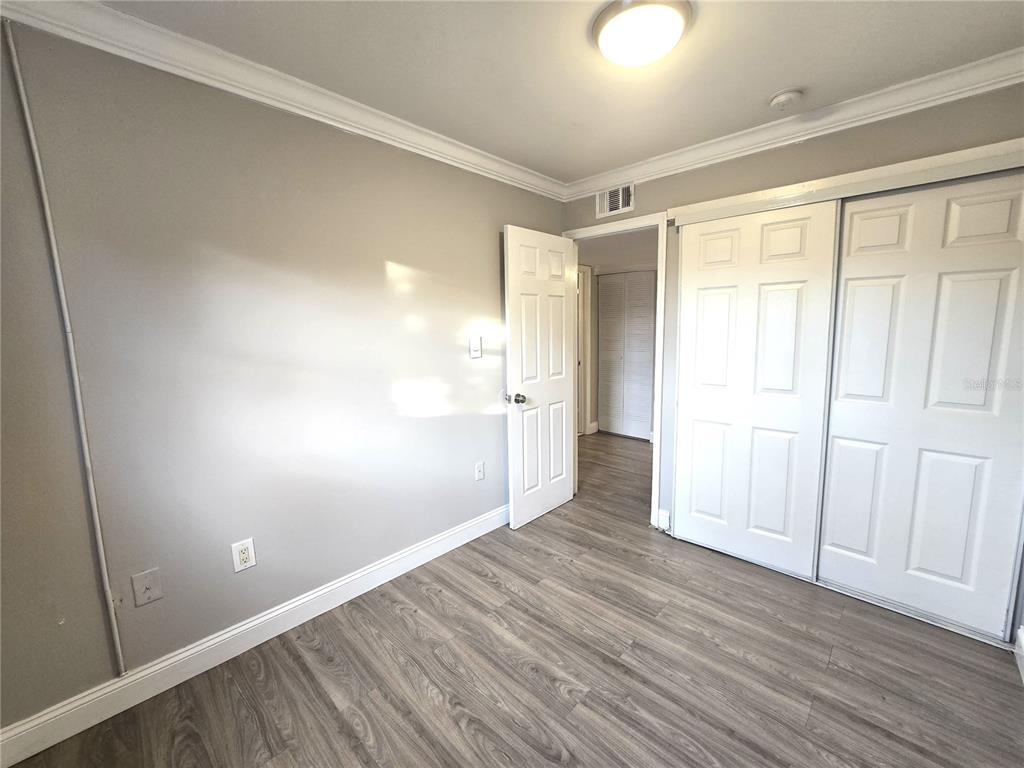 914 Southwest 8th Avenue, Unit 57 Gainesville, FL 32601 - Photo 19 of 31 an empty room with wooden floor and windows