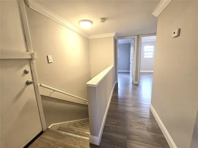 a view of a hallway with wooden floor and staircase