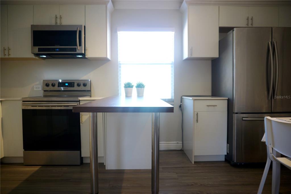 914 Southwest 8th Avenue, Unit 57 Gainesville, FL 32601 - Photo 9 of 31 a kitchen with stainless steel appliances a refrigerator microwave and sink