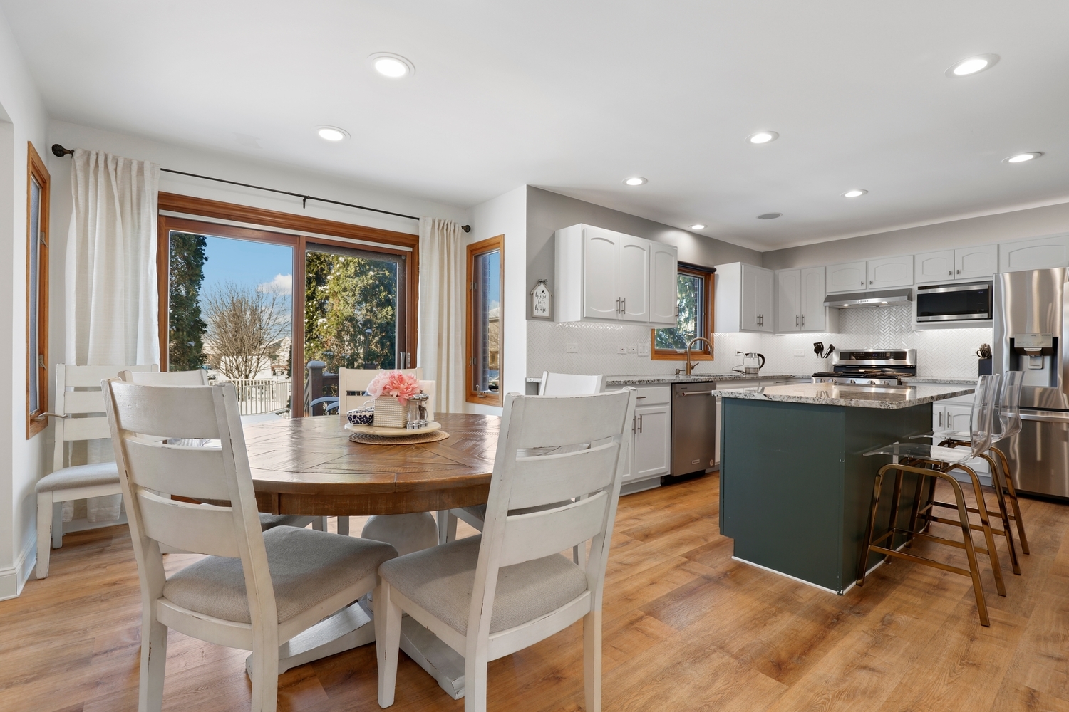 14710 Heathcliff Road Homer Glen, IL 60491 - Photo 4 of 27 a kitchen with a table chairs refrigerator and microwave