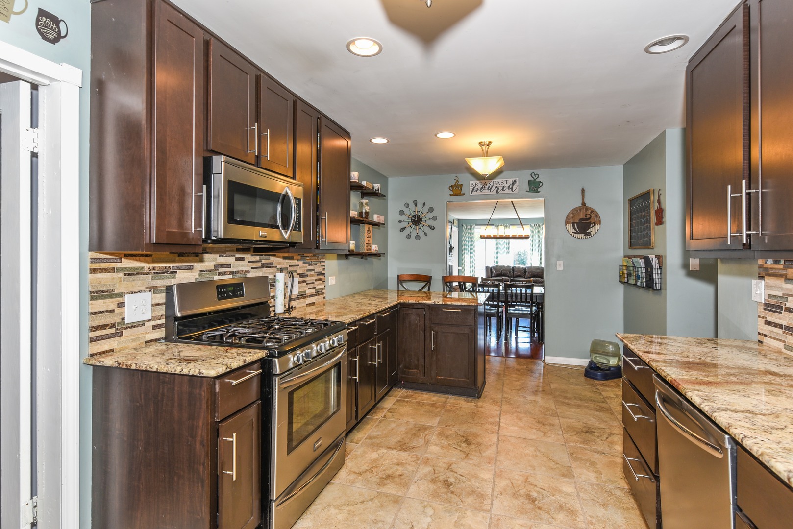 10920 Rutherford Avenue Worth, IL 60482 - Photo 4 of 15 a kitchen with stainless steel appliances granite countertop a stove top oven a sink dishwasher a refrigerator and a dining table with wooden cabinet