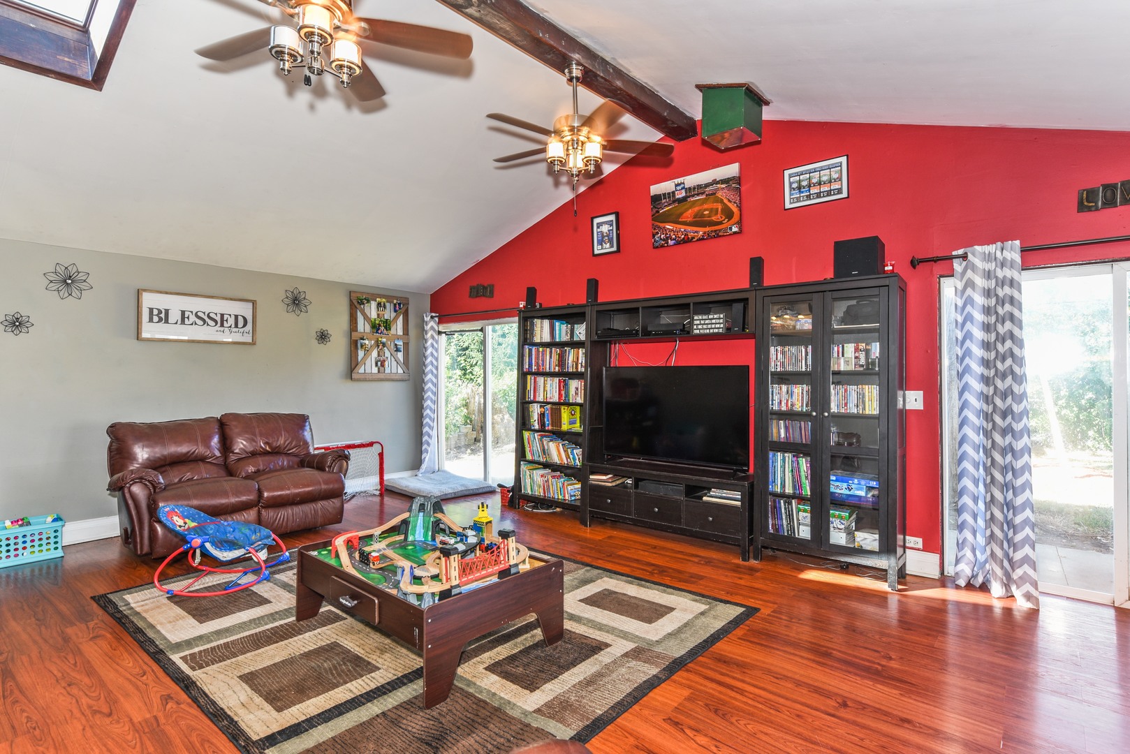 10920 Rutherford Avenue Worth, IL 60482 - Photo 6 of 15 a living room with furniture a flat screen tv and a floor to ceiling window