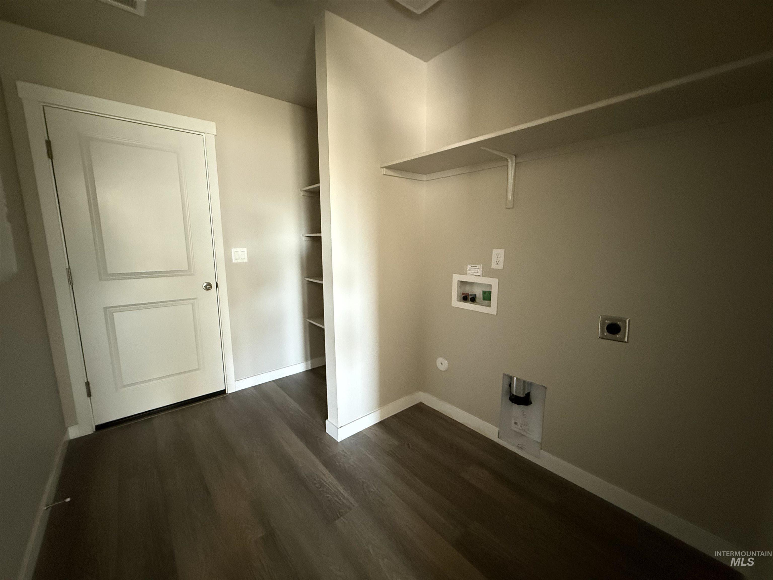 12451 Varga Street Caldwell, ID 83607 - Photo 17 of 30 Wood-finish flooring with a two-panel interior door, featuring a built-in shelving unit and an overhead storage shelf