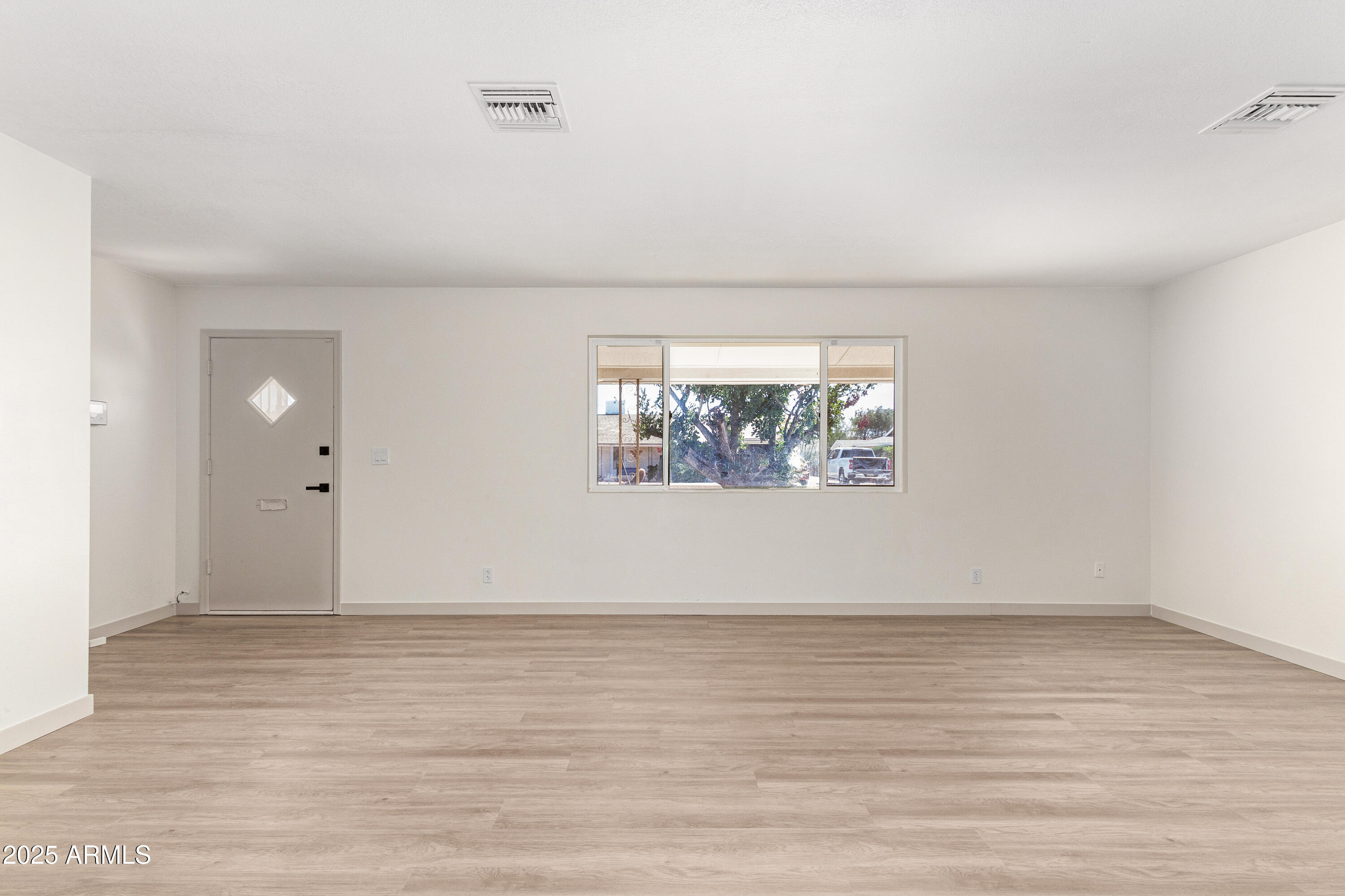5732 Covina Road Mesa, AZ 85205 - Photo 6 of 24 an empty room with wooden floor