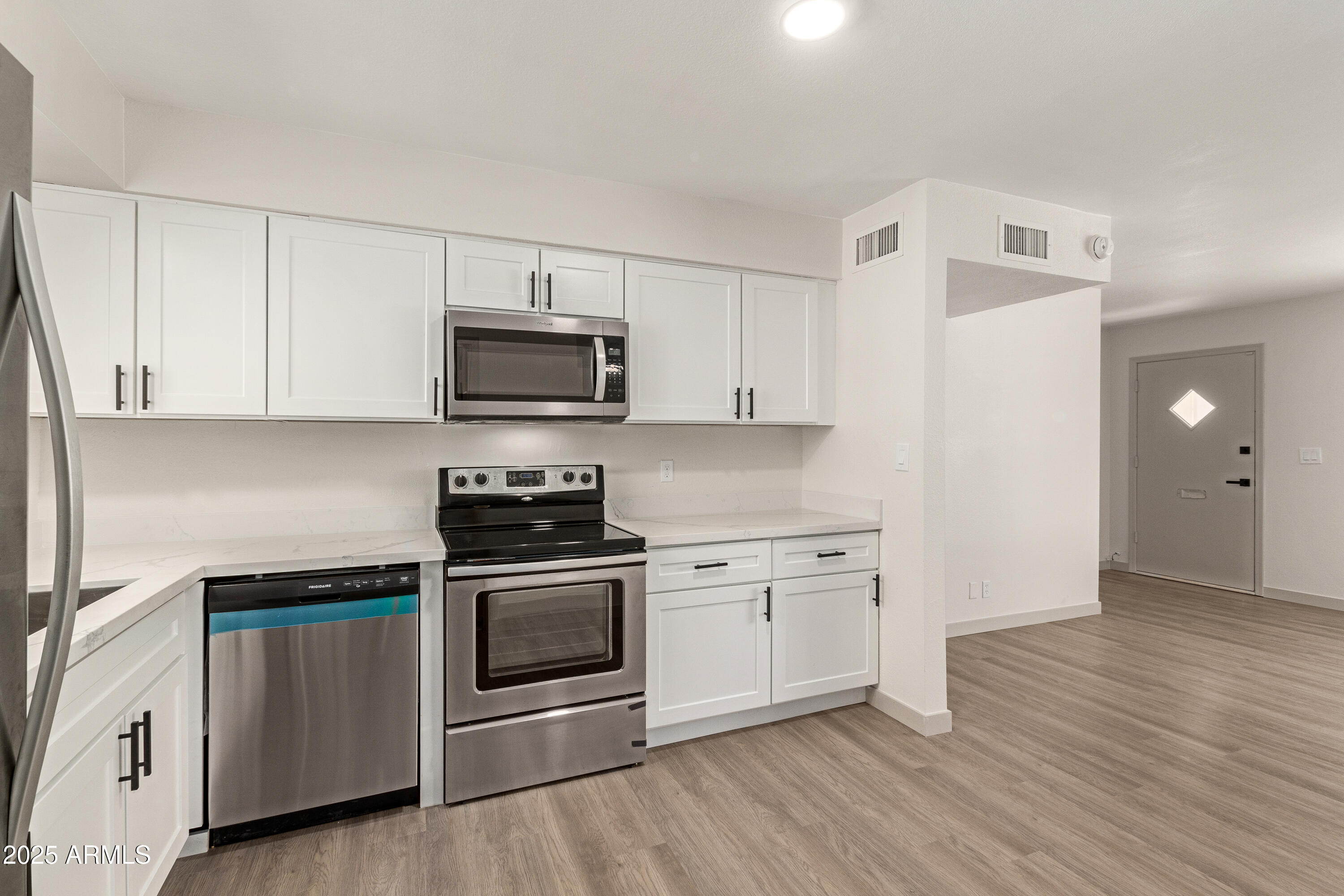 5732 Covina Road Mesa, AZ 85205 - Photo 9 of 24 a kitchen with stainless steel appliances white cabinets and a stove top oven