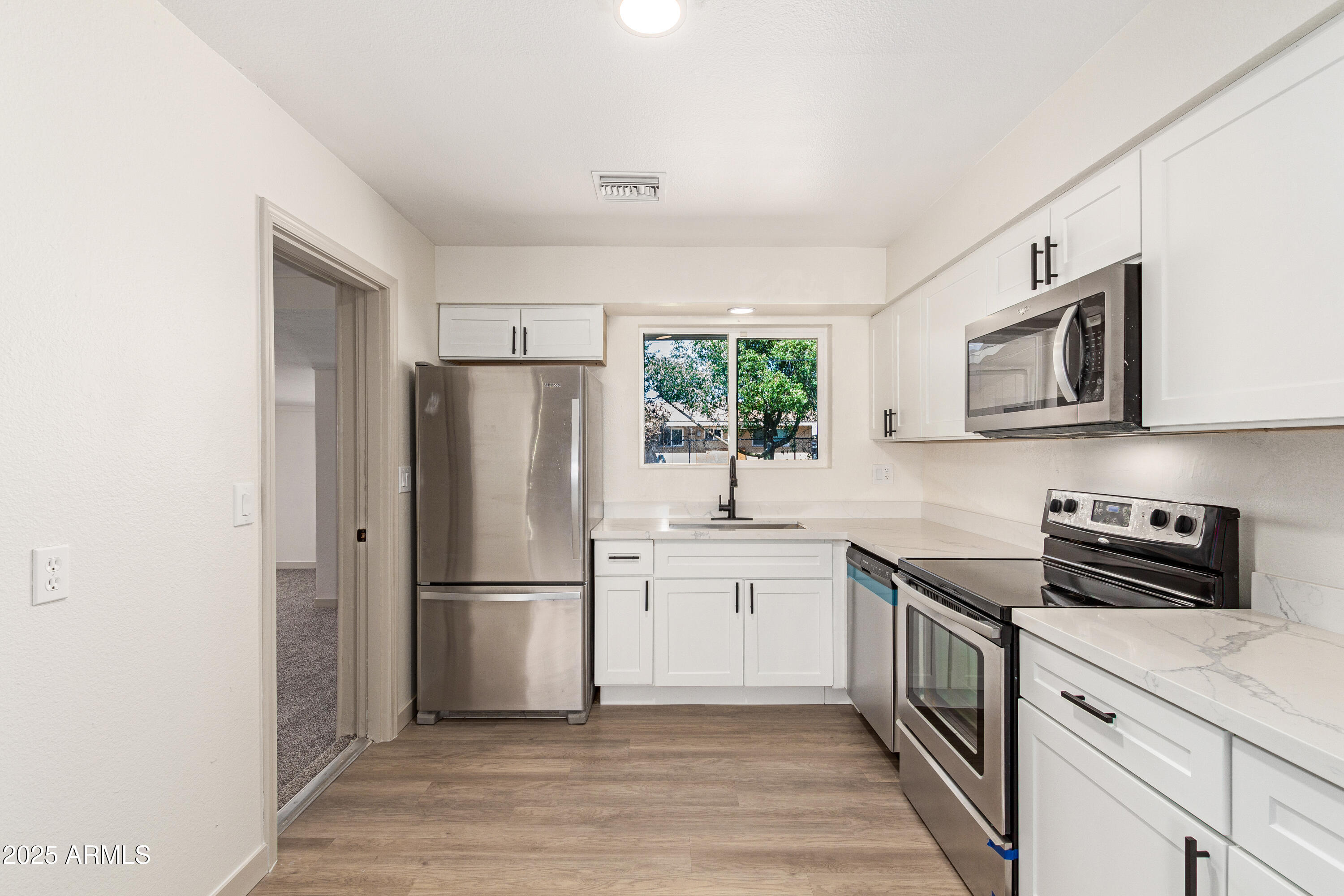 5732 Covina Road Mesa, AZ 85205 - Photo 10 of 24 a kitchen with stainless steel appliances a refrigerator sink and microwave