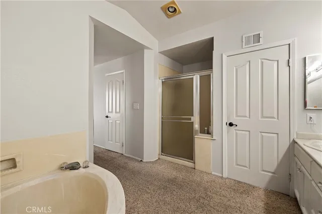 a spacious bedroom with a bed and a shower