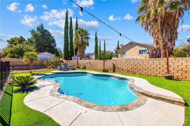 a view of a swimming pool with a patio and a garden