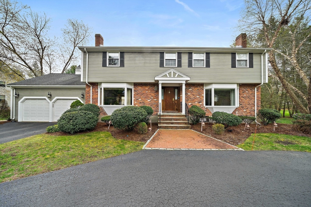 a front view of a house with yard and garage