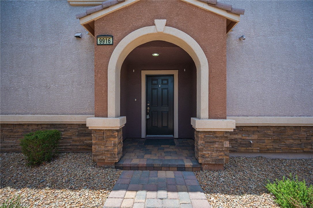 9916 Sable Point Street Las Vegas, NV 89178 - Photo 8 of 73 An inviting entry showcases an arched doorway and a neatly paved walkway.