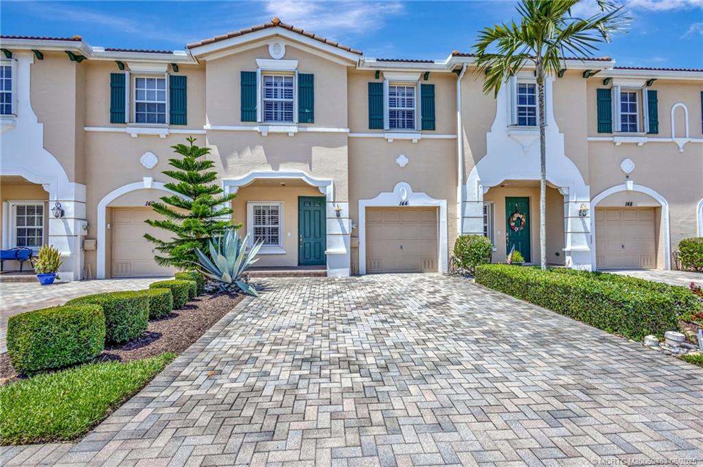 144 Southwest Otter Run Place Stuart, FL 34997 - Photo 1 of 20 a front view of a house with yard and parking