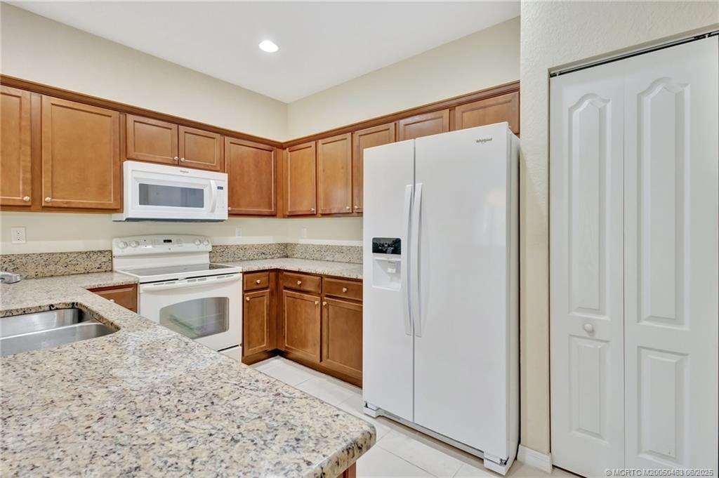 144 Southwest Otter Run Place Stuart, FL 34997 - Photo 4 of 20 a kitchen with stainless steel appliances granite countertop a refrigerator sink and stove