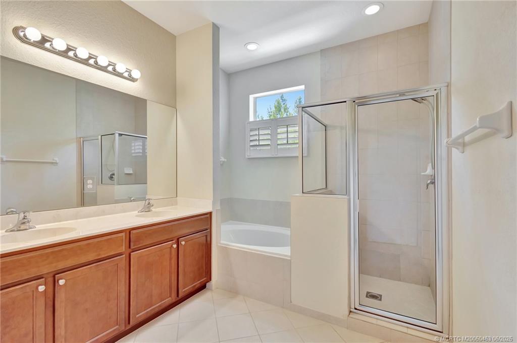 144 Southwest Otter Run Place Stuart, FL 34997 - Photo 10 of 20 a bathroom with a granite countertop sink mirror and a bathtub