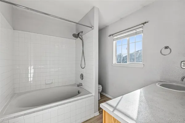 a bathroom with a granite countertop sink a toilet and shower