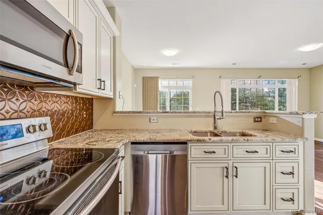 a kitchen with stainless steel appliances granite countertop a sink stove and cabinets