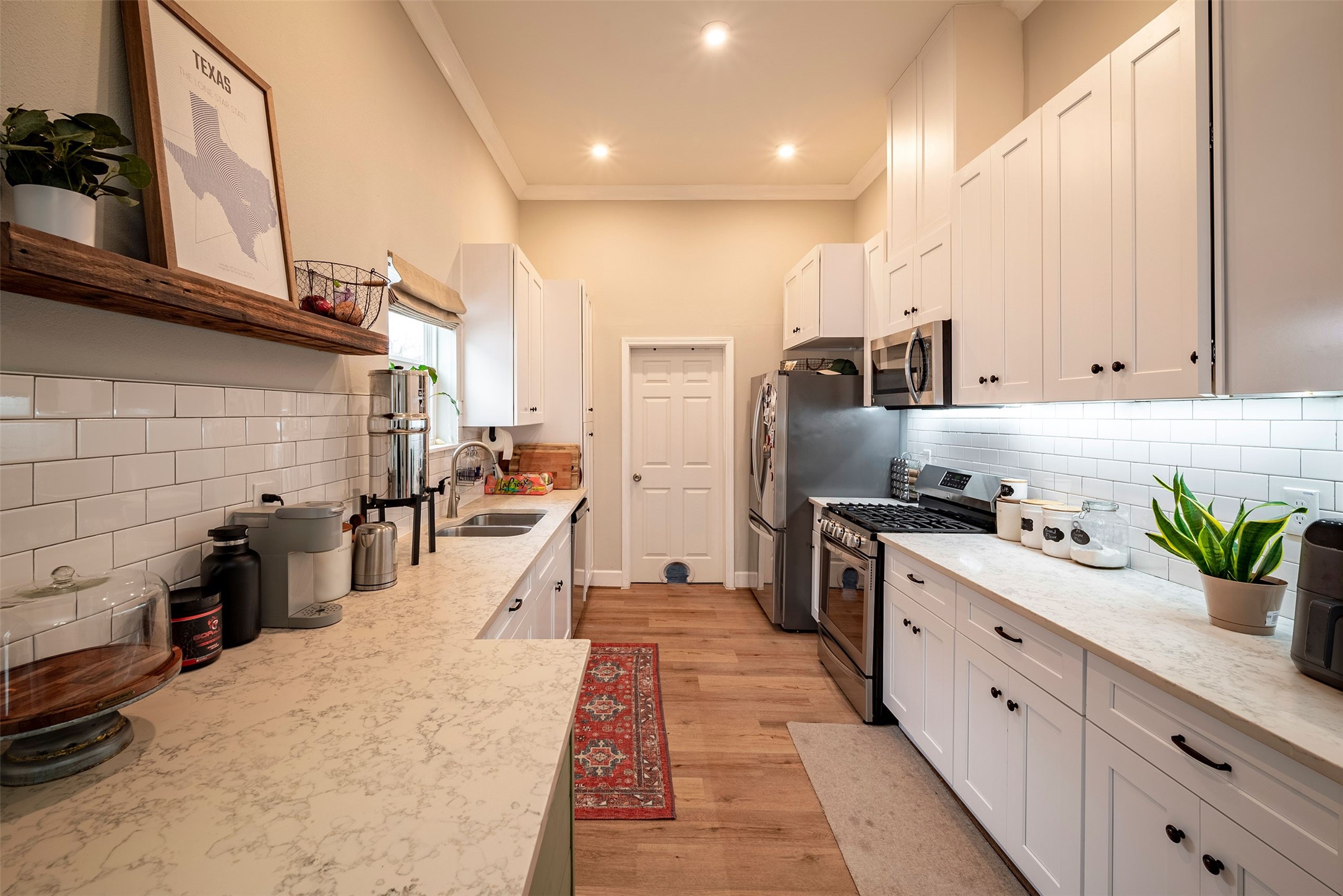 1924 Gano Street Houston, TX 77009 - Photo 5 of 18 a kitchen with stainless steel appliances kitchen island granite countertop a refrigerator a sink dishwasher and white cabinets with wooden floor