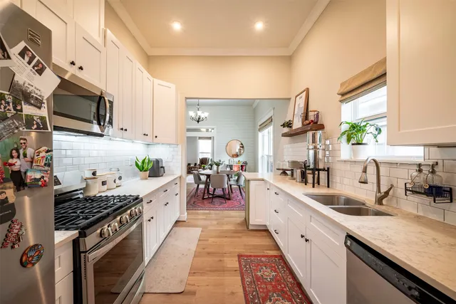 a large kitchen with stainless steel appliances kitchen island granite countertop a lot of counter space and a sink