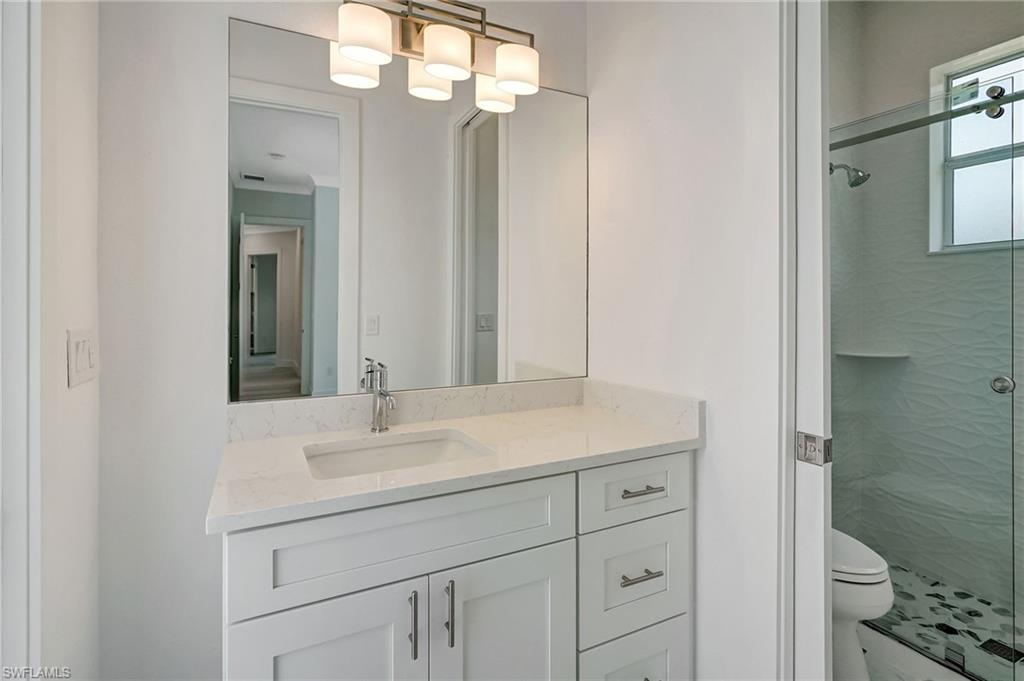 3390 12th Avenue Southeast Naples, FL 34117 - Photo 24 of 48 Bathroom with a stall shower, toilet, and vanity