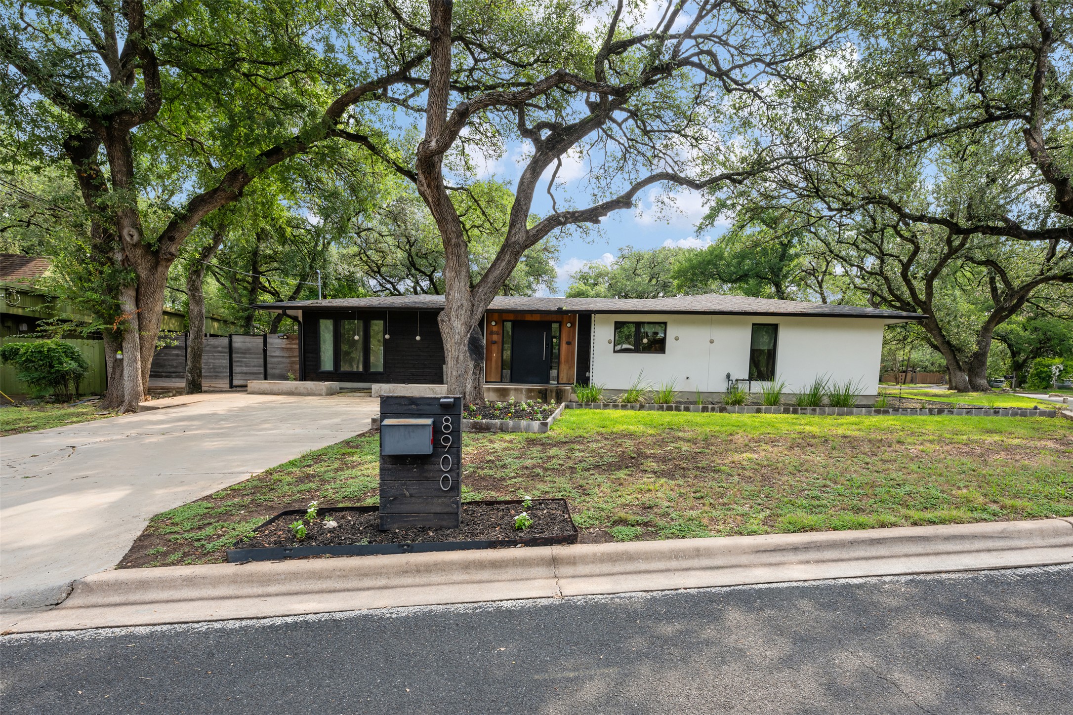 8900 Point W Drive Austin, TX 78759 - Photo 1 of 40 Mature trees frame this modernized ranch home, offering a blend of privacy and contemporary design.