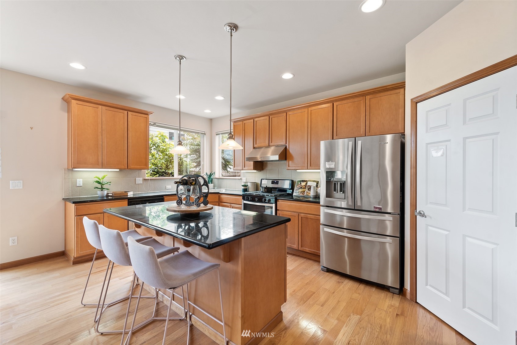 21112 39th Avenue Southeast Bothell, WA 98021 - Photo 9 of 33 a kitchen with stainless steel appliances granite countertop a refrigerator a sink a stove a dining table and chairs