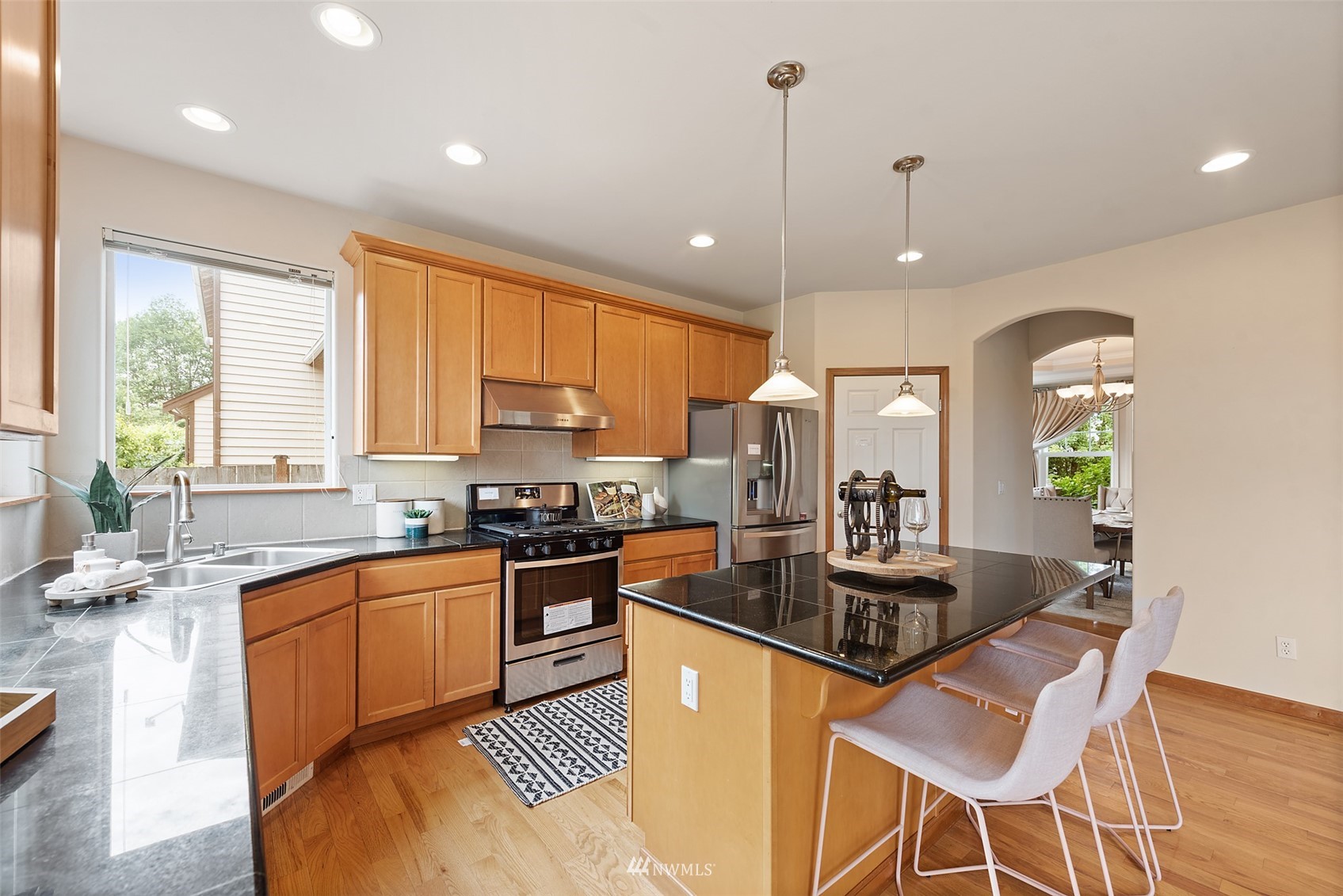 21112 39th Avenue Southeast Bothell, WA 98021 - Photo 10 of 33 a kitchen with granite countertop a stove a sink a refrigerator dining table and chairs