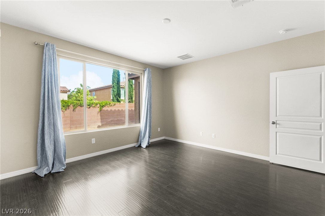 11048 Prairie Grove Road Las Vegas, NV 89179 - Photo 25 of 75 Natural light streams into this generously proportioned room, illuminating the dark hardwood flooring.