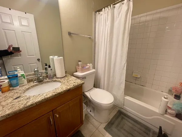 a bathroom with a granite countertop sink toilet and shower