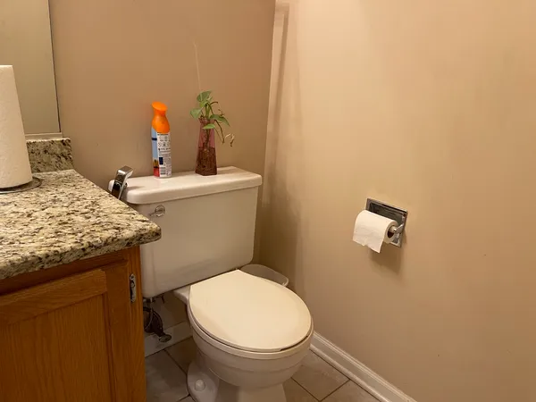 a bathroom with a granite countertop toilet and a sink