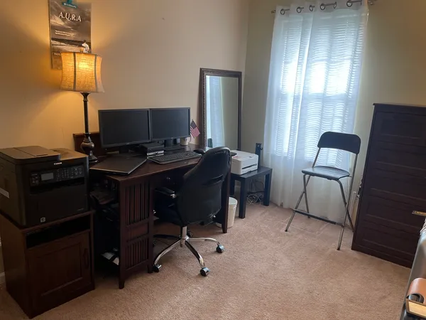 a view of a workspace with furniture and a window