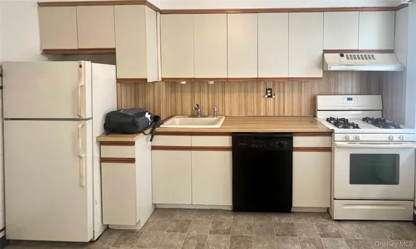 a kitchen with a white stove top oven and refrigerator
