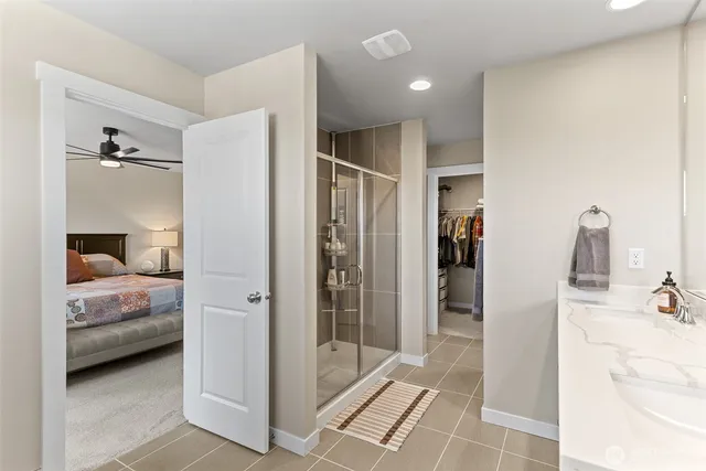 a en suite bathroom with a double vanity sink and glass door