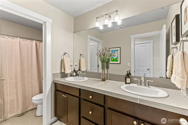 a bathroom with a double vanity sink and a mirror