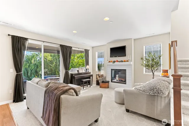 a living room with furniture a fireplace and a large window