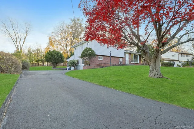 a view of a house with a big yard and large trees