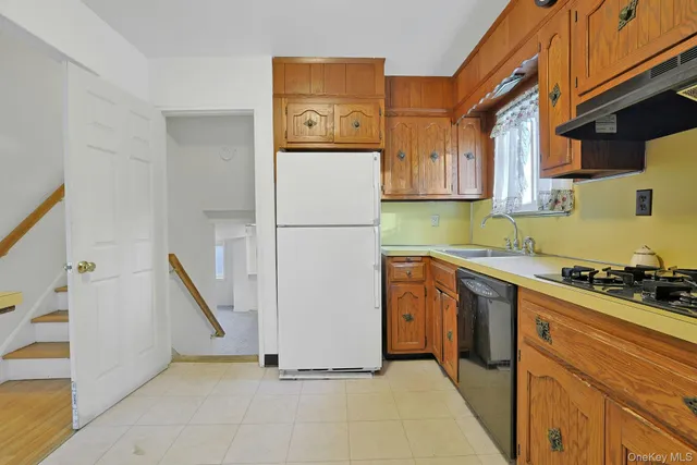 a kitchen with a refrigerator a stove top oven and cabinets