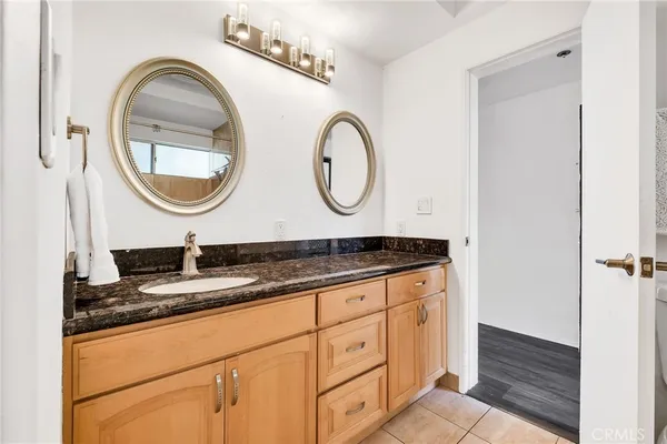 a bathroom with a granite countertop double vanity sink and a mirror