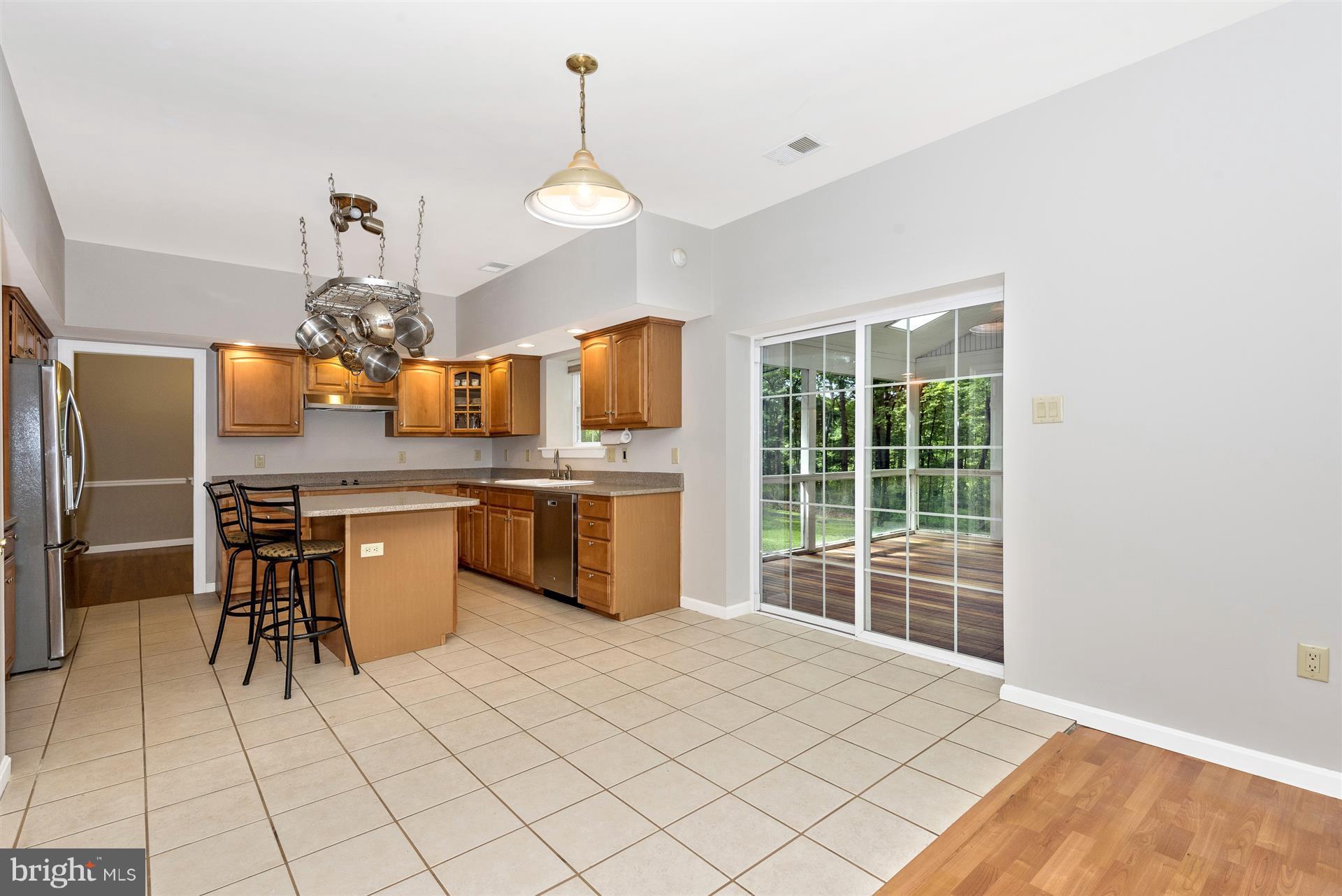 14435 Unionville Road Mount Airy, MD 21771 - Photo 13 of 28 a kitchen with stainless steel appliances kitchen island granite countertop a sink cabinets and wooden floor