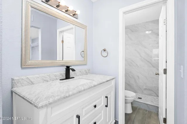 a bathroom with a granite countertop sink toilet and shower