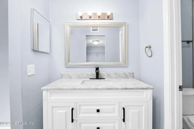 a bathroom with a sink vanity and a mirror