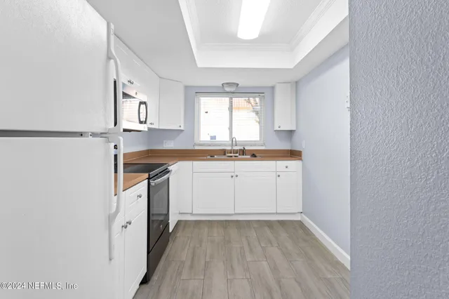 a view of a kitchen with sink cabinets and wooden floor