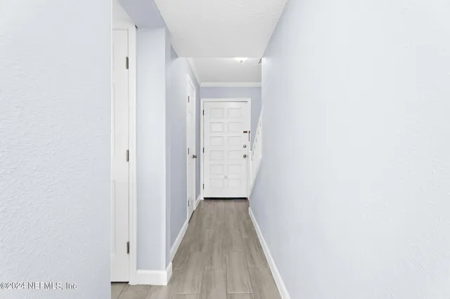 a view of a hallway with wooden floor