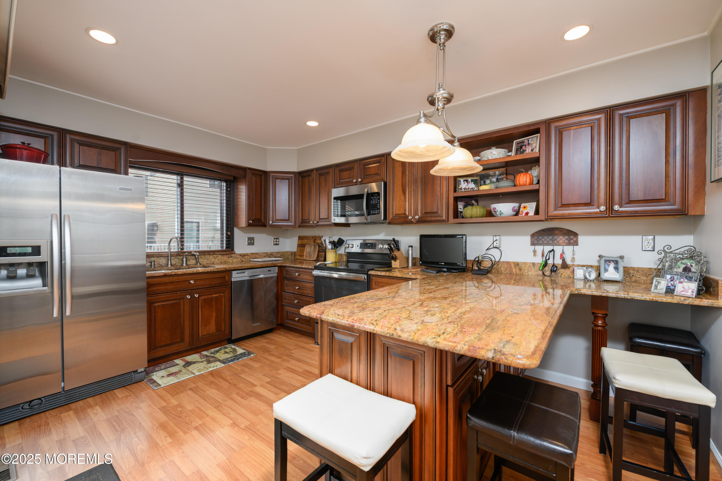 580 Patten Avenue, Unit 31 Long Branch, NJ 07740 - Photo 17 of 30 a kitchen with kitchen island a stove a sink a refrigerator a dining table and chairs
