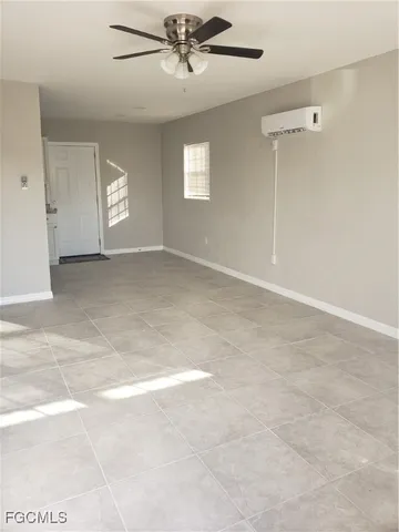 an empty room with windows and ceiling fan