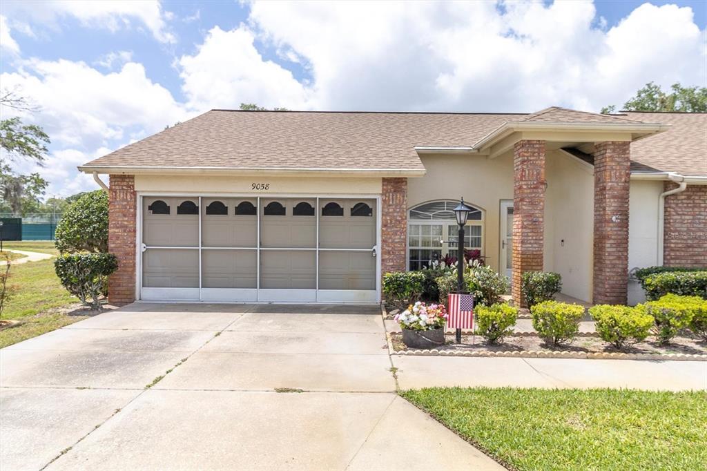 9058 Arundle Place New Port Richey, FL 34655 - Photo 1 of 59 a front view of a house with a yard and garage