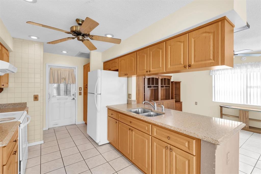 9058 Arundle Place New Port Richey, FL 34655 - Photo 11 of 59 a kitchen with stainless steel appliances granite countertop a sink and cabinets