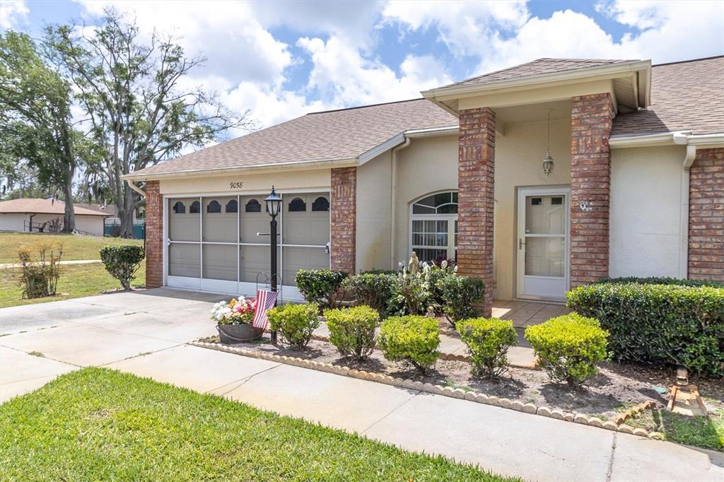 9058 Arundle Place New Port Richey, FL 34655 - Photo 2 of 59 a front view of a house with a yard and flowers