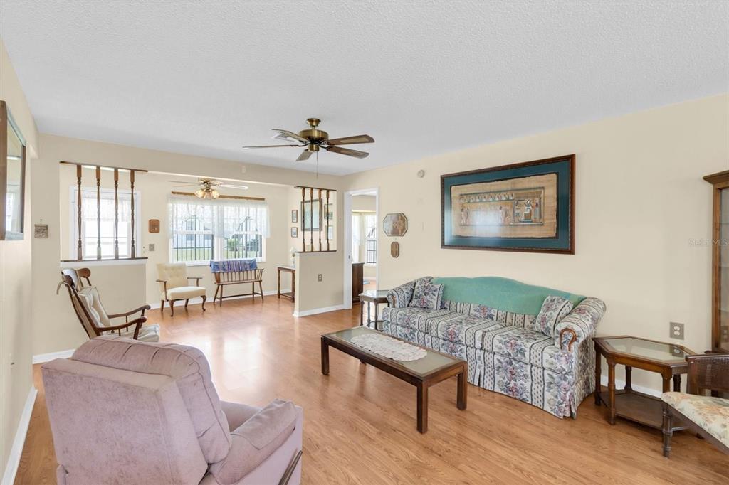 9058 Arundle Place New Port Richey, FL 34655 - Photo 4 of 59 a living room with furniture and a wooden floor
