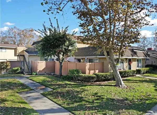 a front view of a house with a yard and trees